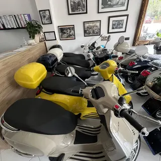 Vespas in the Small & Beautiful showroom, under framed black and white photos